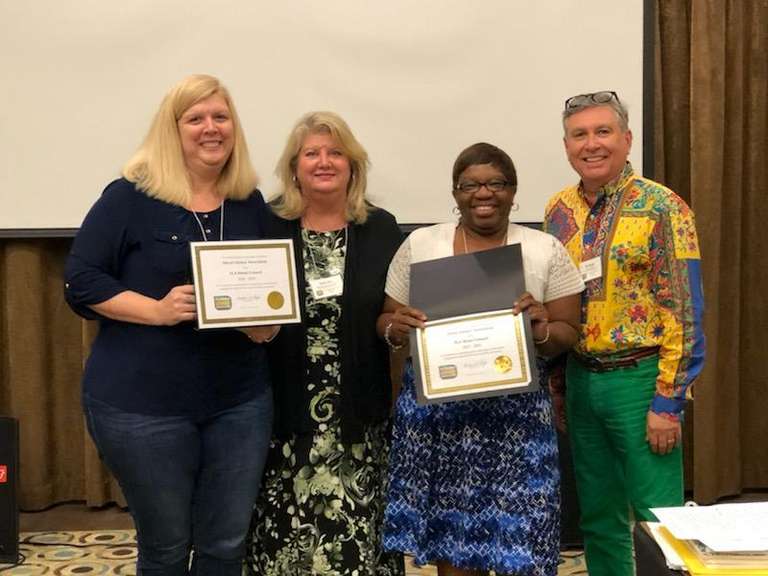 May 2019 - Jessica Fowler, DLA President-elect and Kim Chandler, DLA Vice-president, receive FLA Honor Award certificates from Mary Ann Clark, FLA's  ILA State Coordinator, while FLA President, Dr. Enrique Puig, looks on.